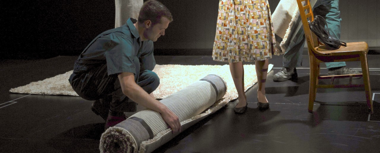 Actor rolling up a rug